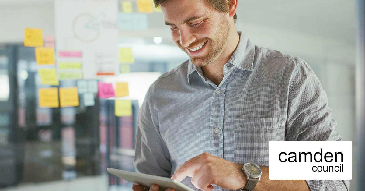 Smiling business man looking at this tablet device