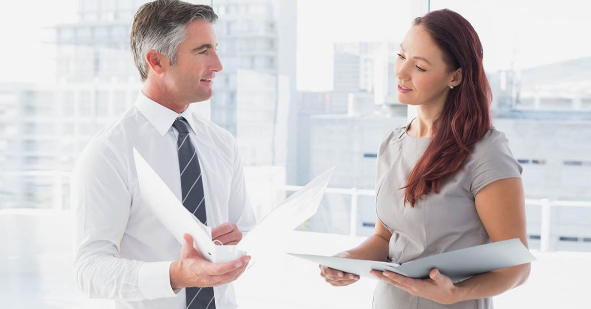 Two business colleagues comparing notes