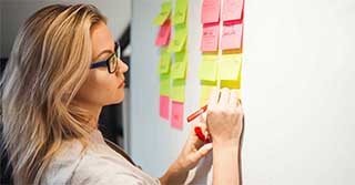 Female executive writing on sticky notes