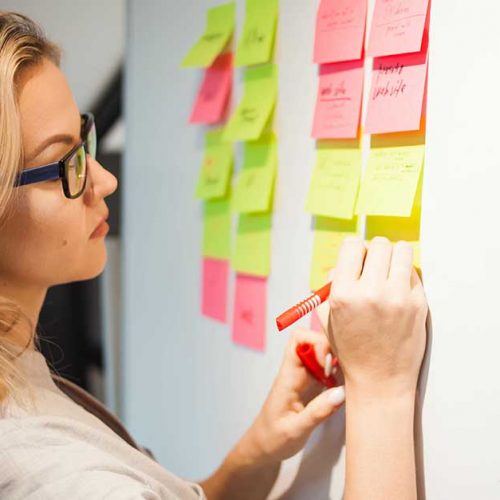 Female executive writing on sticky notes