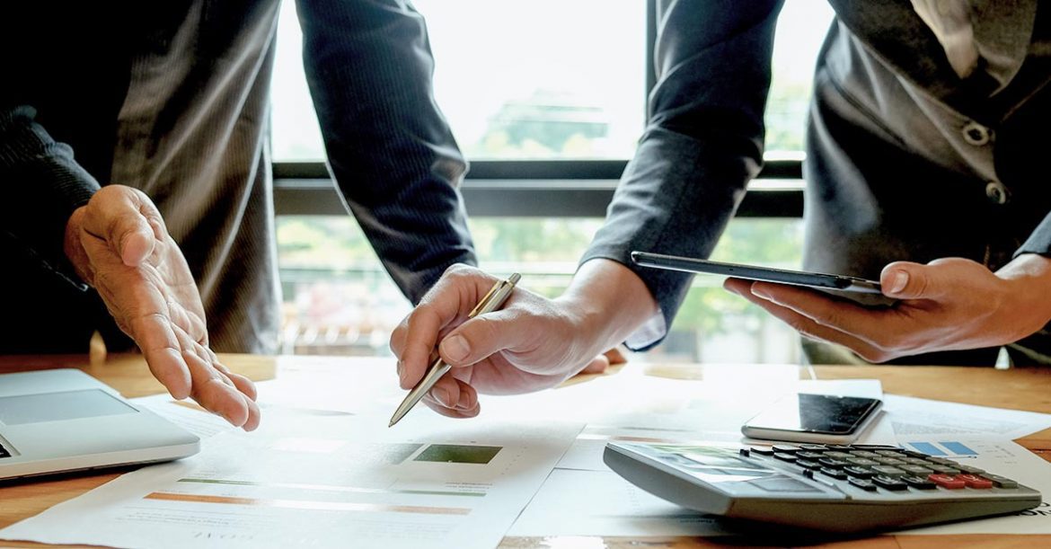 Close up of two business people pointing to a document on the desk