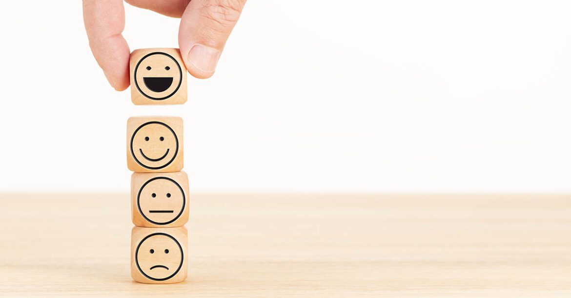 Four wooden dice with smileys