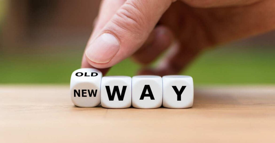 Hand is turning a dice and changes the expression “old way” to “new way”