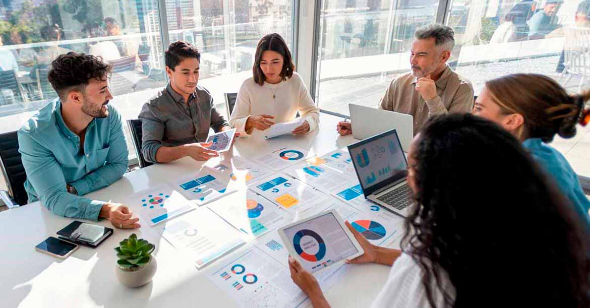 Group of people working with paperwork on a boardroom table at a business presentation